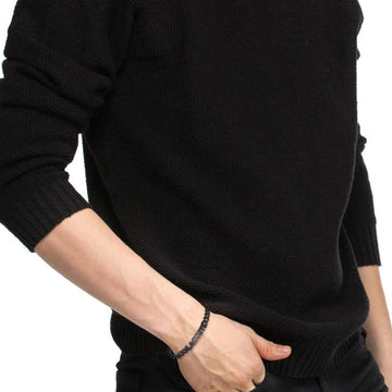 Ανδρικό βραχιόλι Lacoste 2040478 ατσάλινο  μαύρο με το λογότυπο της Lacoste και ρυθμιζόμενο κούμπωμα, φορεμένο.